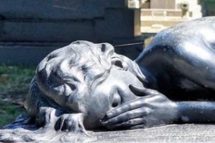 Figur einer weinenden Frau aus Marmor auf dem Friedhof, liegend.