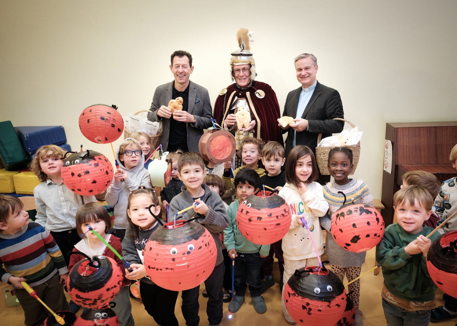 SWB-Kommunikationsleiter Jürgen Winterwerp, Dr. Christoph Rhein (St. Martin der Münstergemeinde) und Stadtdechant Msgr. Dr. Markus Hofmann (v.l.n.r.) überreichen Weckmänner an Kinder des katholischen Kindergartens St. Joseph.
