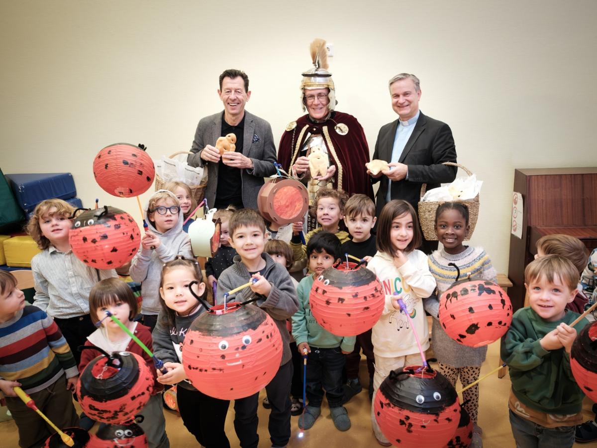 SWB-Kommunikationsleiter Jürgen Winterwerp, Dr. Christoph Rhein (St. Martin der Münstergemeinde) und Stadtdechant Msgr. Dr. Markus Hofmann (v.l.n.r.) überreichen Weckmänner an Kinder des katholischen Kindergartens St. Joseph.