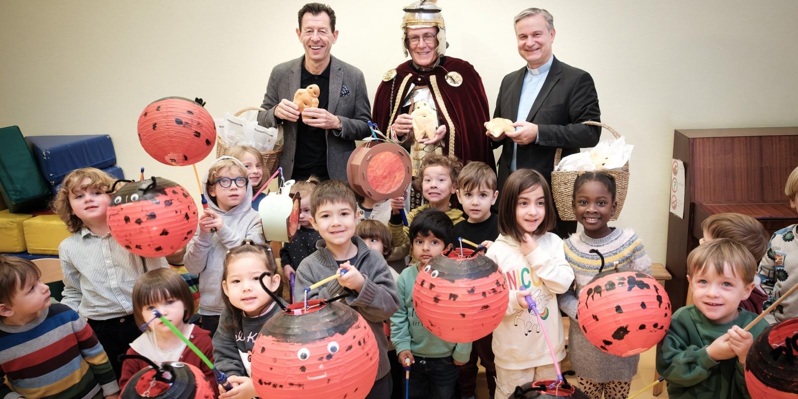 SWB-Kommunikationsleiter Jürgen Winterwerp, Dr. Christoph Rhein (St. Martin der Münstergemeinde) und Stadtdechant Msgr. Dr. Markus Hofmann (v.l.n.r.) überreichen Weckmänner an Kinder des katholischen Kindergartens St. Joseph.