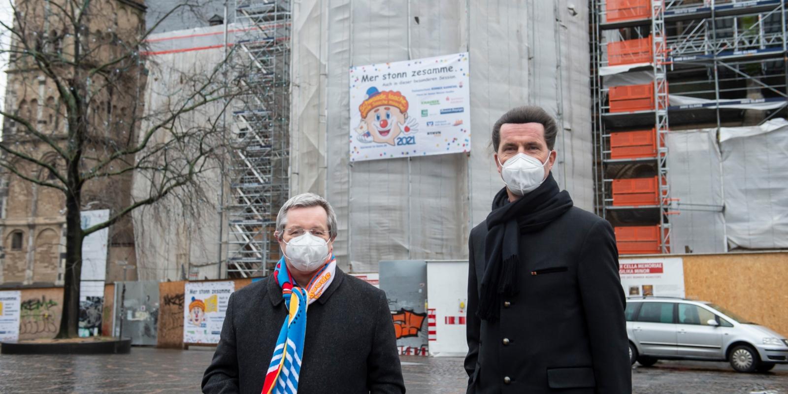 Festausschuss-Vizepräsident Stephan Eisel (links) und Stadtdechant Dr. Wolfgang Picken präsentieren das Banner am Bonner Münster