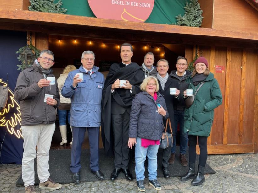 Stadtdechant Dr. Wolfgang Picken (3.v.l.) und Pfarrer Uwe Grieser (3.v.r.) eröffneten mit Vertretern der Institutionen am Sonntag die Engelhütte auf dem Weihnachtsmarkt.